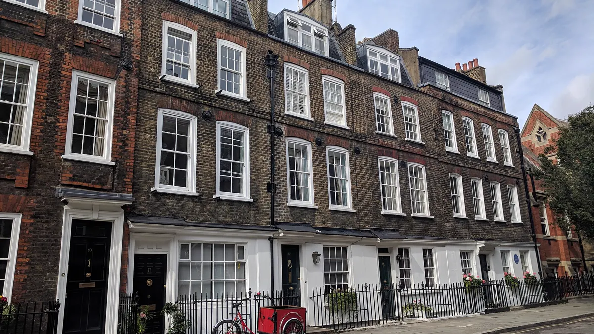 A terrace of tall brick Georgian houses on a London street