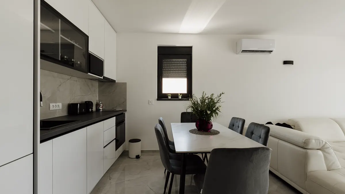 A clean, modern kitchen and dining room in a simple home